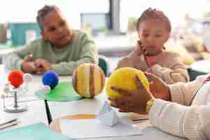 Free photo kids learning about planets in classroom