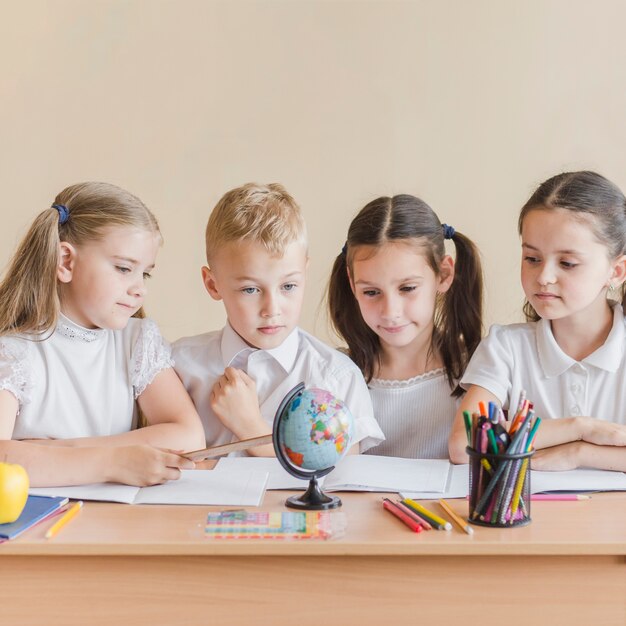 Kids looking at globe at school