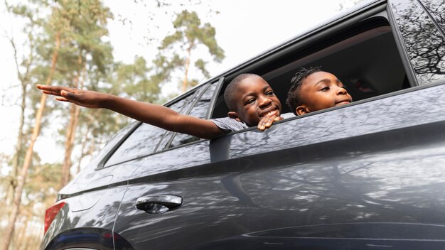 Дети смотрят на улицу через окно машины