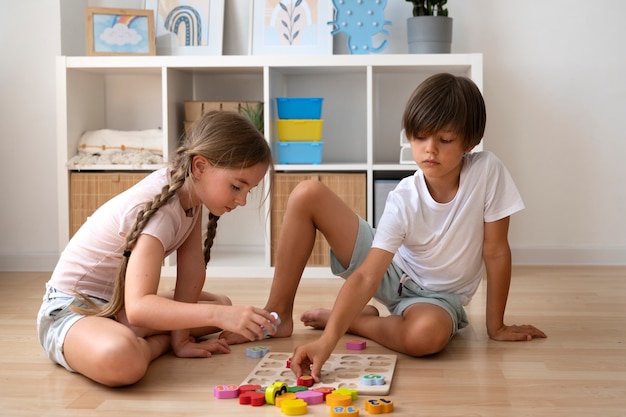 Kids making puzzle together full shot