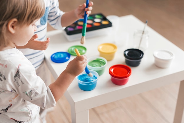 Free photo kids painting together at home