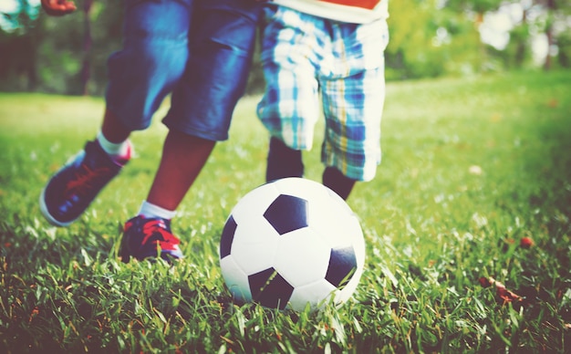 Bambini che giocano a calcio su un prato