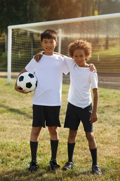 Kids playing football supervised by football trainer