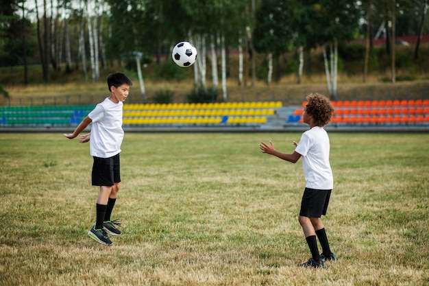 Kids playing football supervised by football trainer