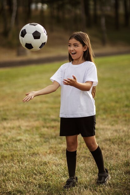 Kids playing football supervised by football trainer