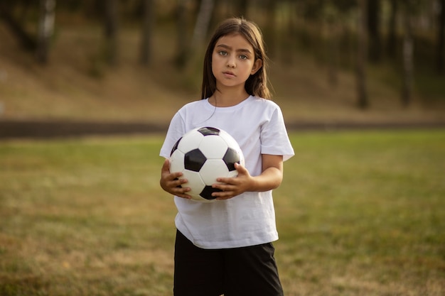 Free photo kids playing football supervised by football trainer