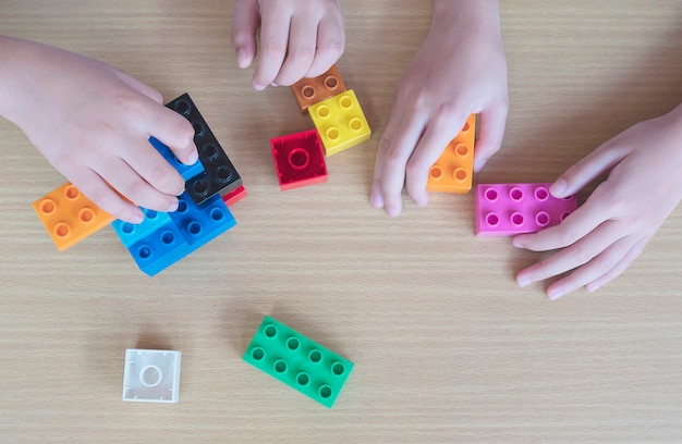 プラスチック製の創造的な建設ブロックを遊んでいる子供たち