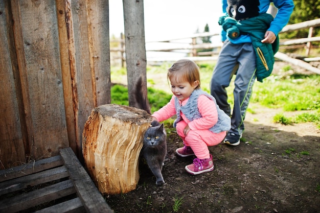 山の村で猫と遊ぶ子供たち
