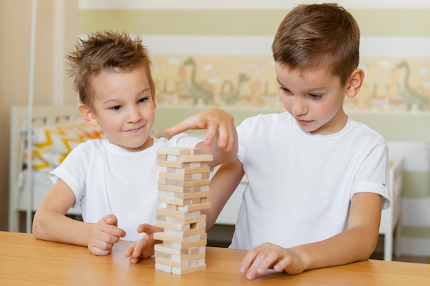 Дети вместе играют в деревянную башню