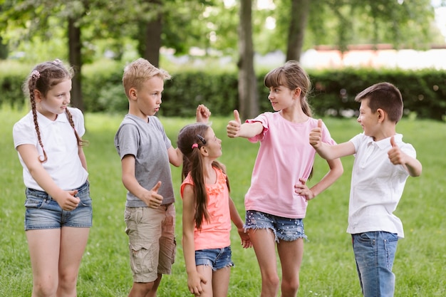 Bambini in posa e facendo il segno ok