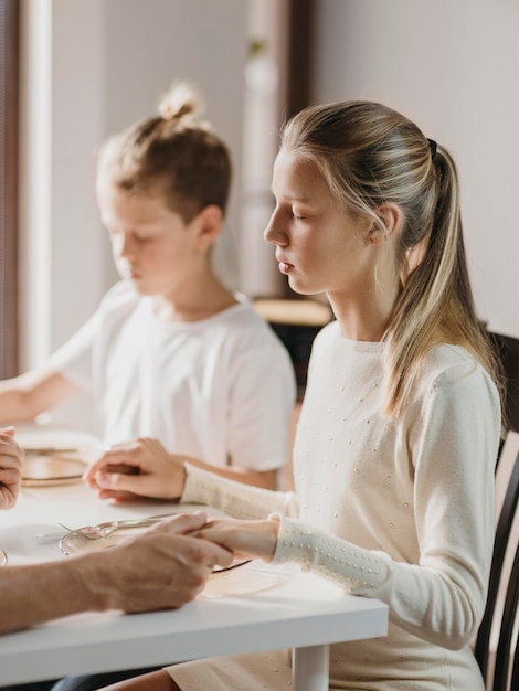 Foto gratuita bambini che pregano prima di mangiare