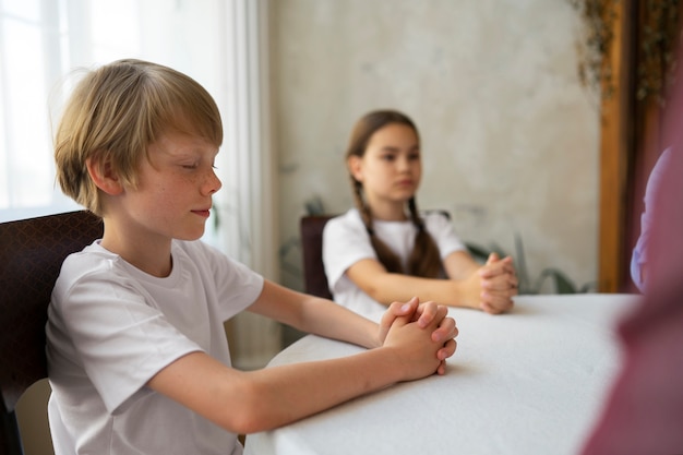 Free photo kids praying together side view