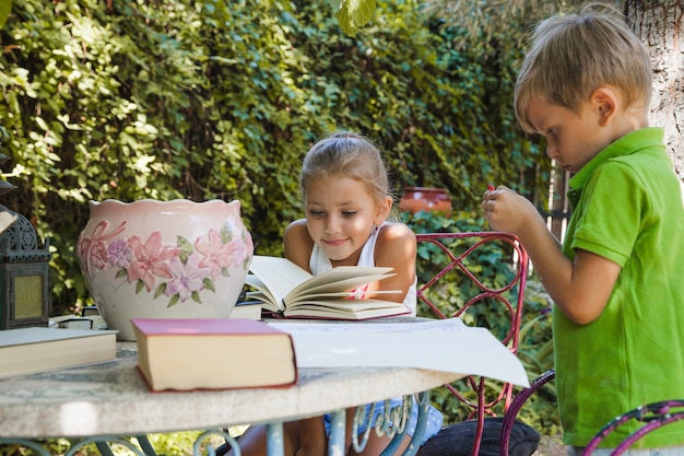 庭のテーブルで読書する子供たち