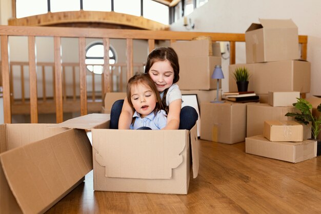 Kids sitting in box  full shot