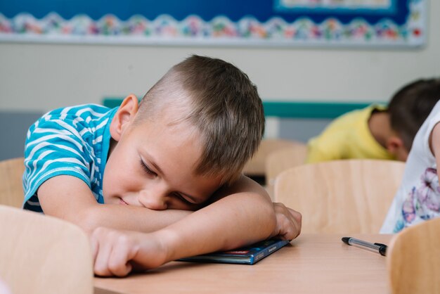 Kids sleeping on table in classroom