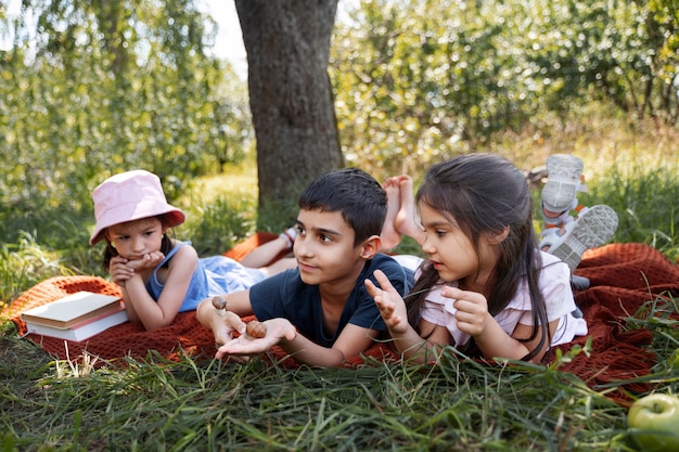 Kids spending time together outdoors on blanket enjoying childhood