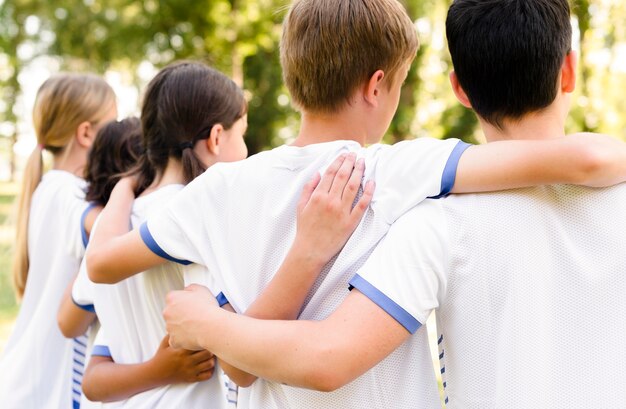 Kids in sportswear holding each other