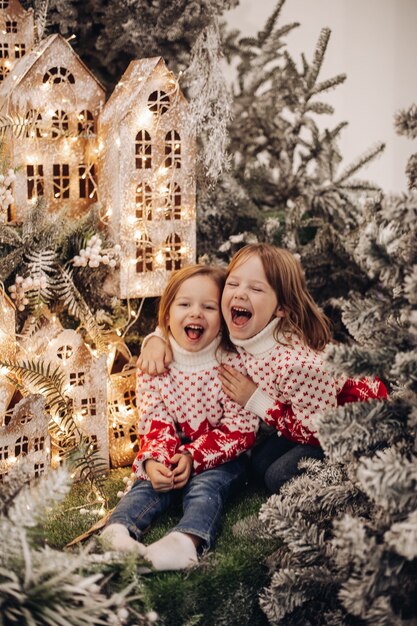 クリスマスの飾りの上に立っている子供たち