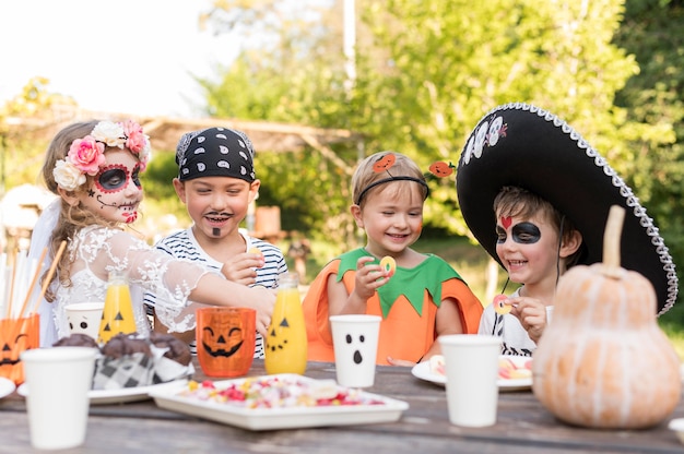 ハロウィーンの衣装のテーブルで子供たち