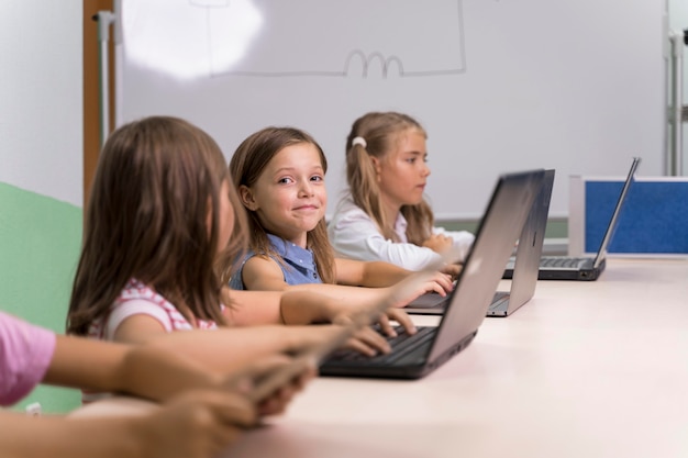 Kids using laptop at school