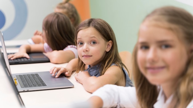 Kids using laptop at school