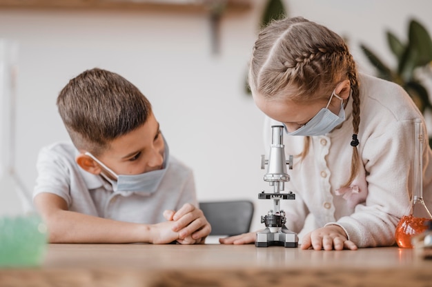 Bambini che usano un microscopio per imparare la scienza