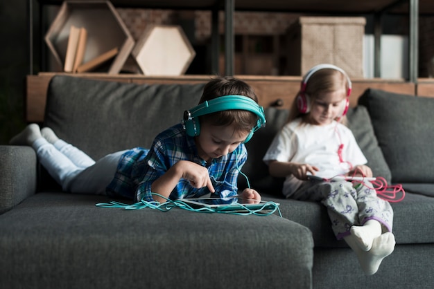 Kids using tablets on couch