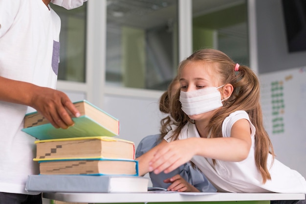 Kids wanting to take a book from a desk