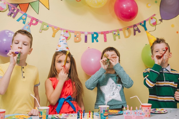 Bambini con noise makers su barty di compleanno