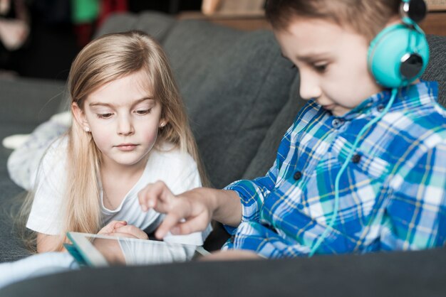 Kids with tablet on couch