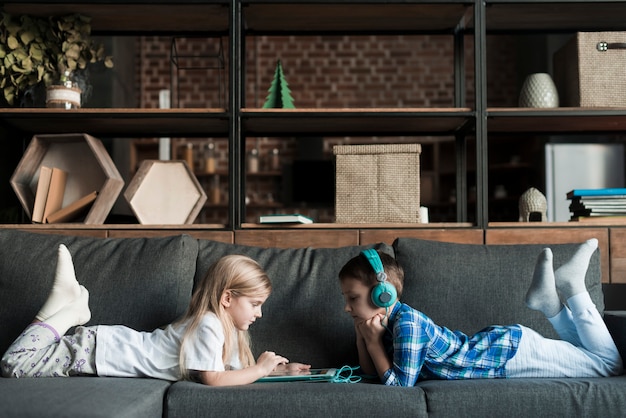 Free photo kids with tablet on couch