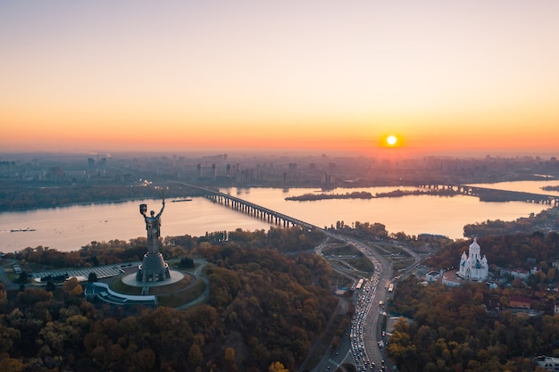 美しい燃えるような夕日、ウクライナのキエフのスカイライン。記念碑の祖国。
