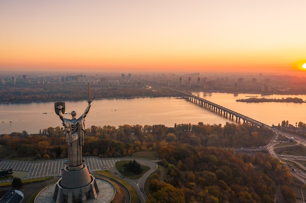 Киевский горизонт над красивым пламенным закатом, Украина. Памятник Родине.