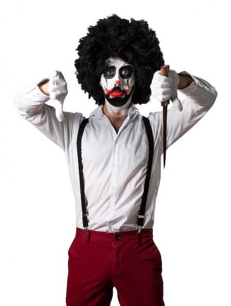 Free photo killer clown with knife making bad signal