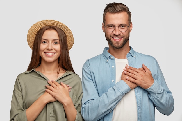 Free photo kind hearted lovely couple posing against the white wall