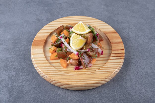 A kind of vegetables in the wooden plate , on the marble surface.