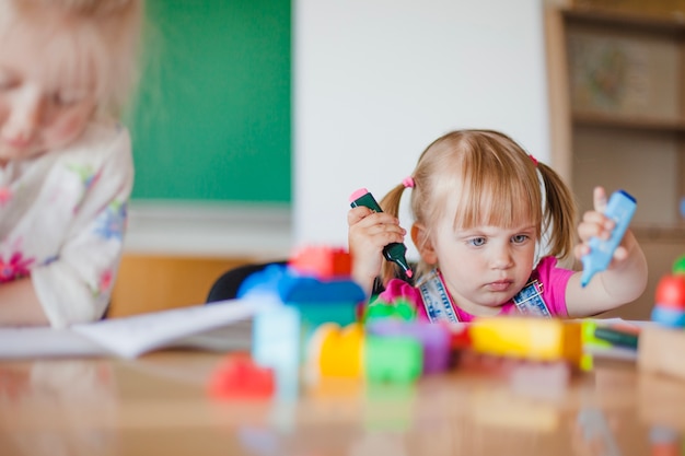 Kindergarten girl playing with markers