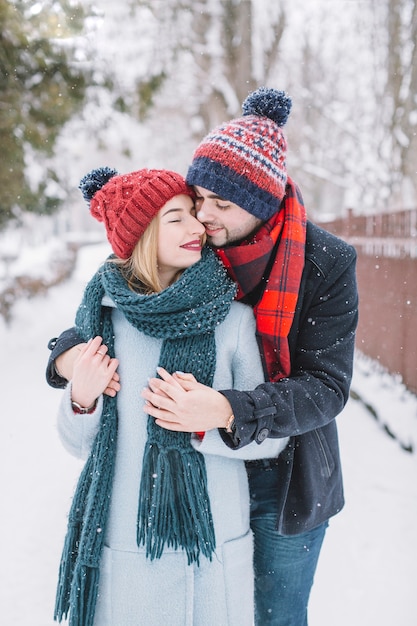 雪の中でキスするカップル