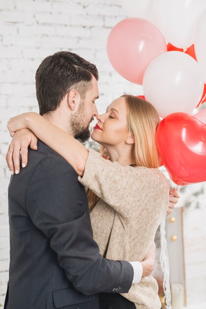 Kissing couple with heart-shaped balloons