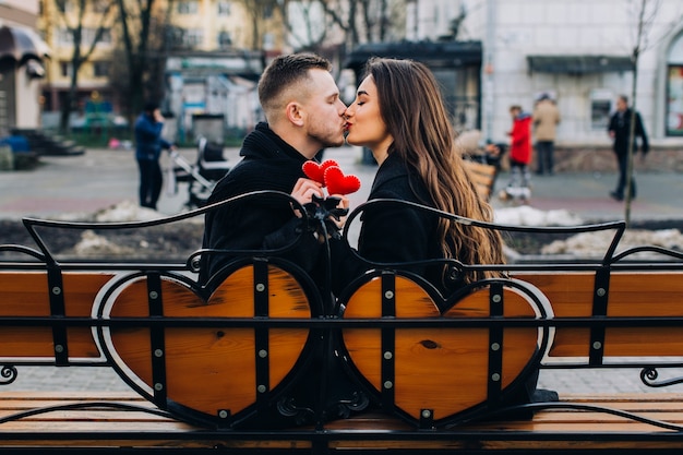 Поцелуи романтической пары на скамейке