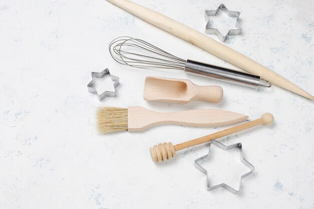 Kitchen baking utensils with spices for cookies and cookie cutters on light surface