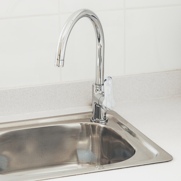 Free photo kitchen faucet with near a white wall