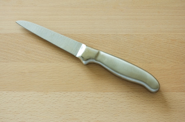 kitchen knife on brown wooden board