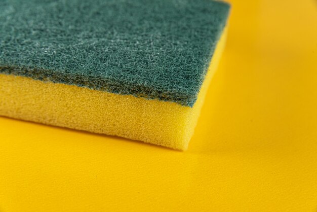 Kitchen sponge on the yellow background