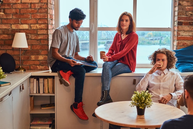 Kitchen in student dormitory. Group of interracial students resting in student dormitory.