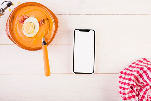 Kitchen table with soup plate and smartphone