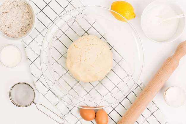 Kitchen utensil; dough; flour; milk; egg and lemon for cooking