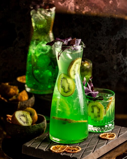 Kiwi cooling juice in a decanter with basil leaves