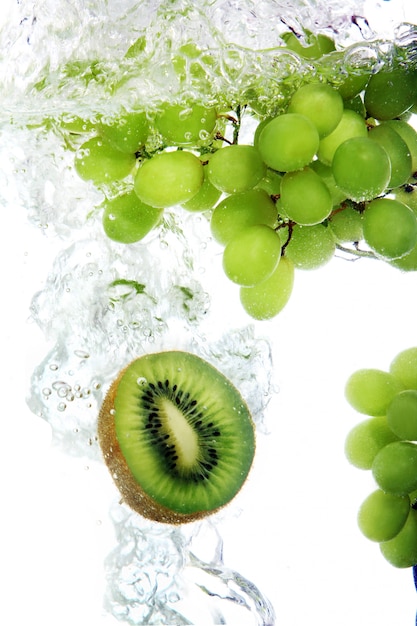 Free photo kiwi and grape dropped into water