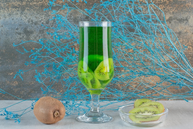 Succo di kiwi con kiwi intero e fiore appassito. foto di alta qualità